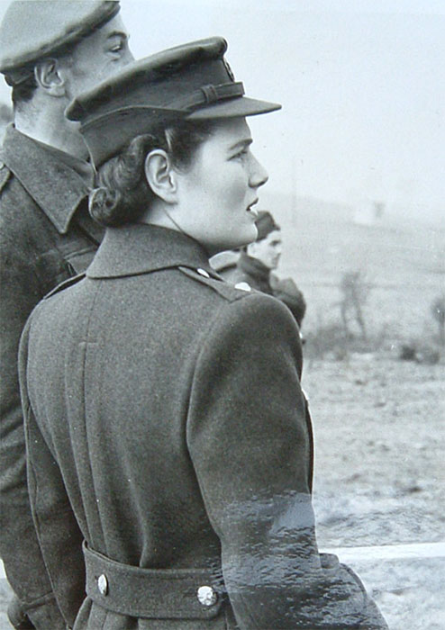 Black and white half length photograph of Mary Churchill with another soldier watching infantry training (out of shot), 1942