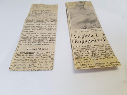 Two newspaper clippings lying face down on a table. The one on the left has had the adhesive removed, there is a slightly faded section where the adhesive had been. The clipping on the right still has patches of the yellowish adhesive.