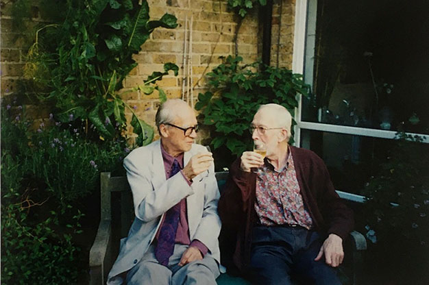 Michael Young and Peter Wilmott sitting in a garden with drinks