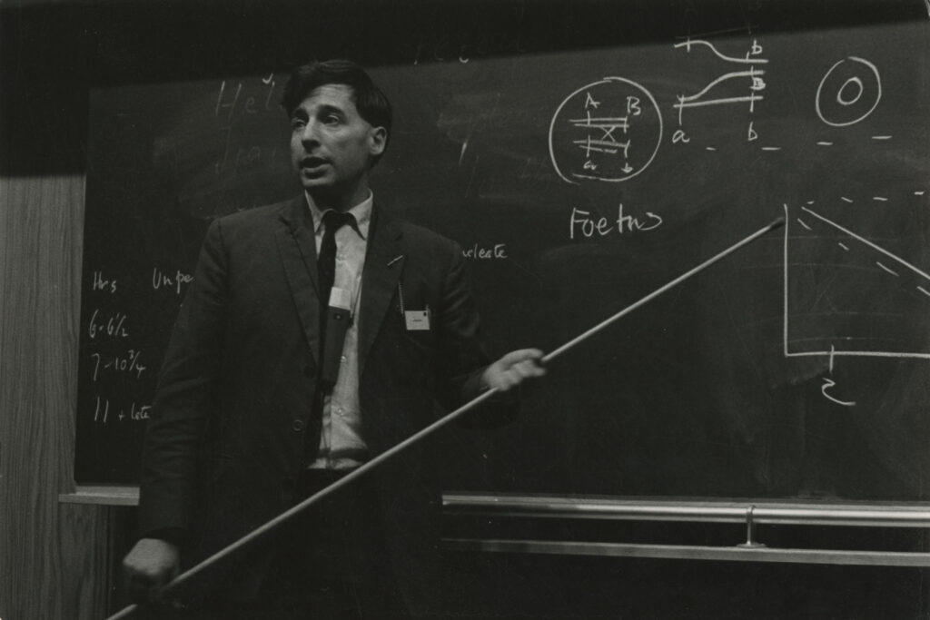 Robert Edwards standing at a black board.