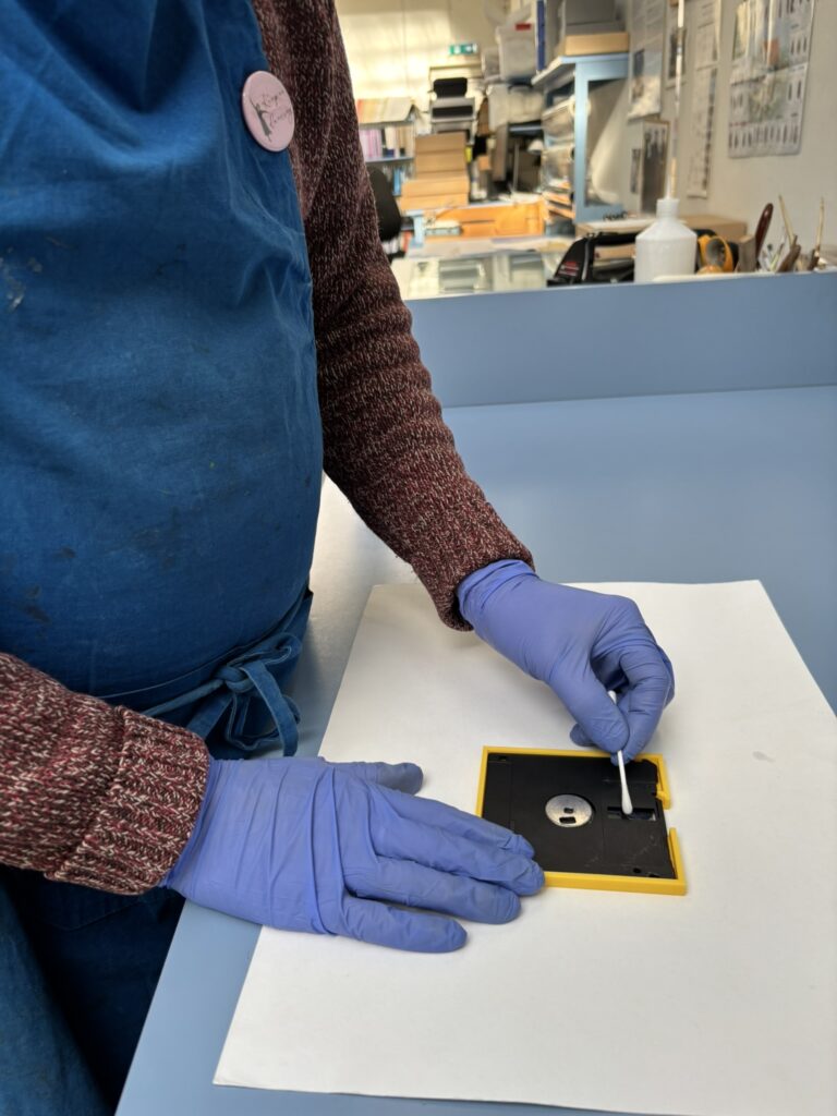 David cleaning the surface of the floppy disk.
