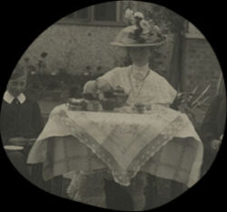 Black and white photograph of Else Headlam-Morley sitting at a tea table, pouring tea